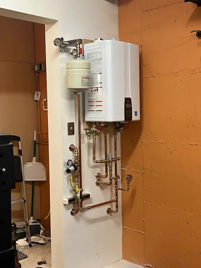 Plumbing technician inspecting water heater connections in Rosemont